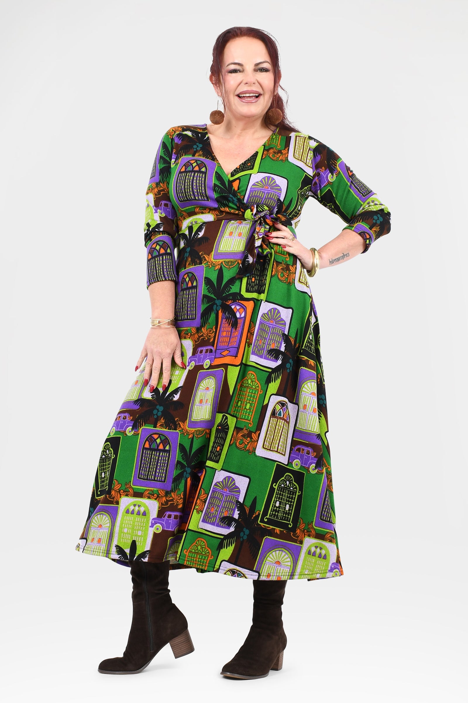 Woman wearing a colorful dress with a pattern of haunted houses on a white background