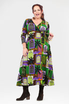 Woman wearing a colorful dress with a pattern of haunted houses on a white background