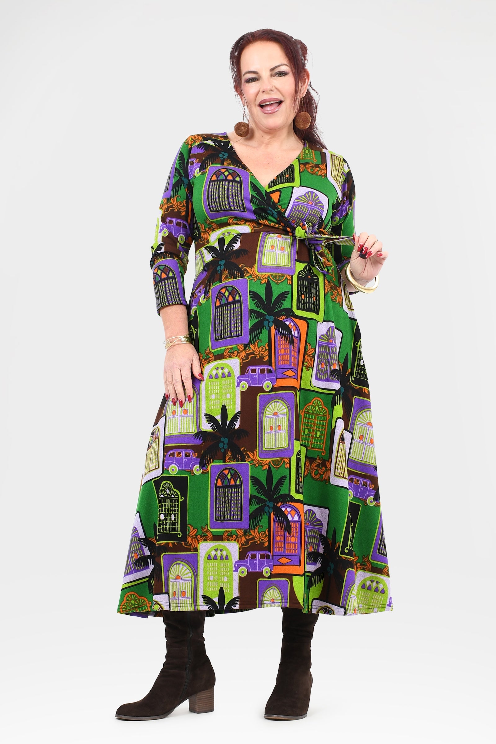 Woman wearing a colorful dress with a pattern of haunted houses on a white background