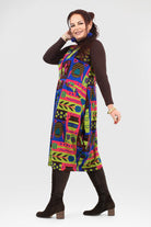 Woman wearing a colorful patterned dress on a white background