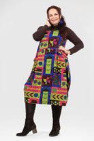 Woman wearing a colorful patterned dress with a white background