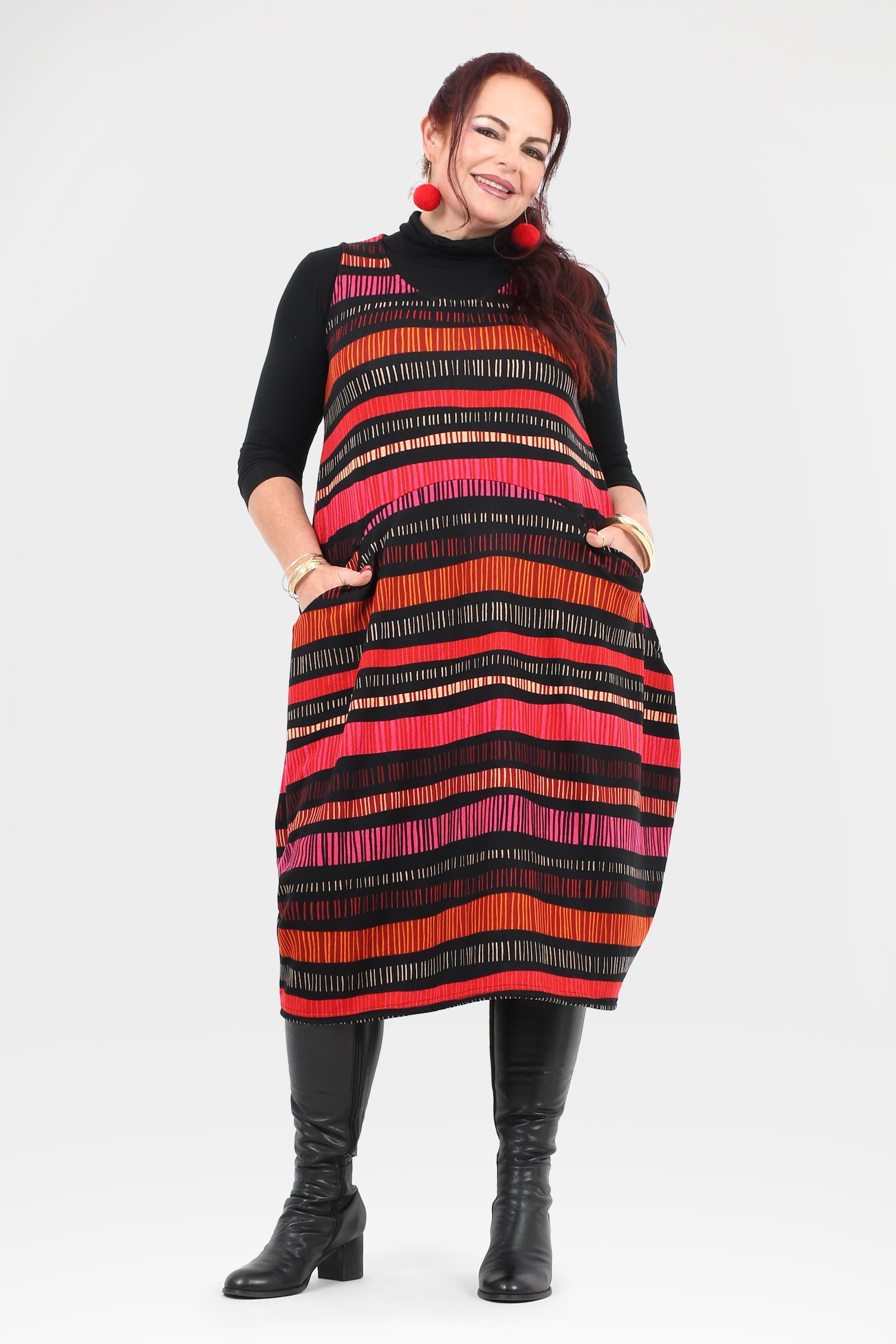 Woman wearing a black and red striped dress with a plain background