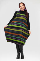 Woman wearing a colorful striped dress on a white background